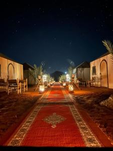 eine Straße in der Nacht mit Lichtern auf der Straße in der Unterkunft Sahara Tours luxury camp in Merzouga