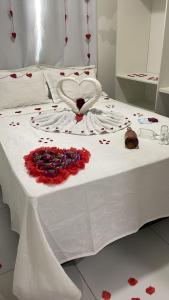uma cama branca com um coração feito de flores em Encantos de Maragogi em Maragogi