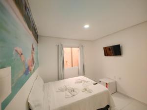 een witte kamer met een bed met een witte tafel bij Encantos de Maragogi in Maragogi