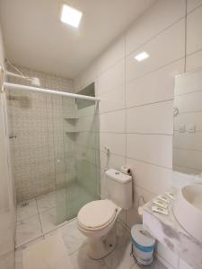 a bathroom with a toilet and a shower and a sink at Encantos de Maragogi in Maragogi