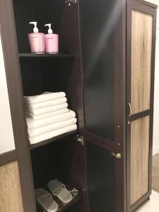 a black cabinet with towels and toiletries in a bathroom at The Living - Holiday Home Phayao in Phayao