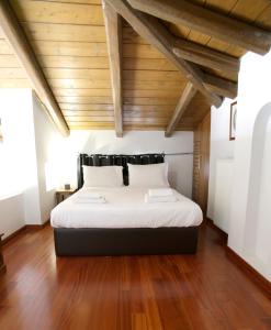 Cette chambre dispose d'un grand lit et de plafonds en bois. dans l'établissement Aθens Dome - Apartments by Live&Travel, à Athènes