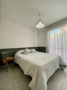 a bedroom with a large white bed in a room at Departamento amoblado in Villa María