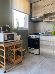 a kitchen with a stove and a microwave at Departamento amoblado in Villa María