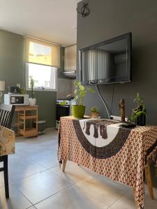 a kitchen with a table and a tv on the wall at Departamento amoblado in Villa María