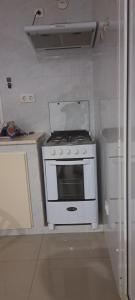 uma cozinha com um fogão branco e um frigorífico em Apartamento T1 Mobilado Espargos/Sal em Espargos