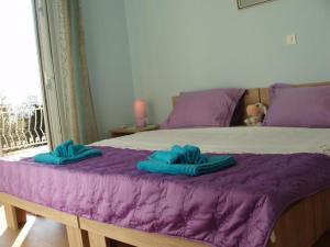 a bed with purple sheets and blue towels on it at Va Zamete in Rijeka