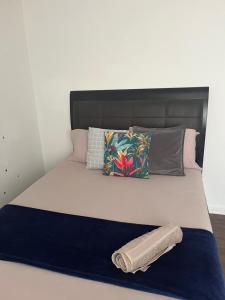 a bed with a headboard and pillows on it at Juana's private room in Manchester