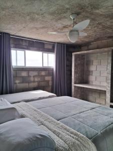 1 dormitorio con 2 camas y ventilador de techo en Casa Concept, en Mucugê