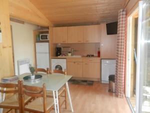 een keuken met een tafel en stoelen in een kamer bij Gites Les Chrisalies in Pont-Saint-Esprit
