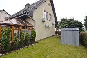 a house with a fence in front of a yard at Villa Andre in Jarosławiec