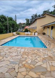 una piscina di fronte a una casa di Casa Aconchegante em Serra Negra a Serra Negra