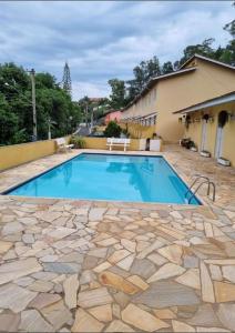 a swimming pool in front of a house at Casa Aconchegante em Serra Negra in Serra Negra