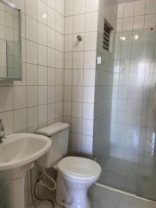 y baño con aseo, lavabo y ducha. en Studio ótima localização, en Foz do Iguaçu