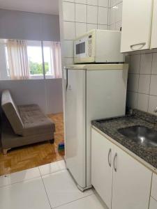 a kitchen with a refrigerator and a microwave at Studio ótima localização in Foz do Iguaçu