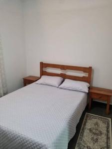 a bedroom with a bed with two pillows on it at Casa Aconchegante em Serra Negra in Serra Negra