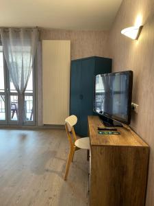 a room with a tv on a desk with a chair at Relais Vosgien - Hôtel Restaurant "la Table de Sophia" in Saint-Pierremont