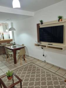 a living room with a large flat screen tv on a wall at Casa Aconchegante em Serra Negra in Serra Negra +33 photos
