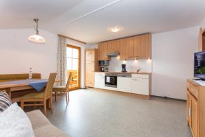 a kitchen and living room with a table and a dining room at Klockergut in Sankt Veit im Pongau