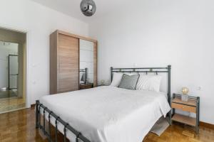 a bedroom with a large white bed and a mirror at On The Port in Rafina