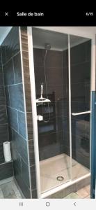 een glazen douchedeur met een stoel in de badkamer bij Appartement F1 tout équipé de plein pied in Scey-en-Varais