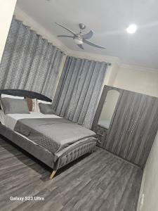 a bedroom with a bed and a ceiling fan at Fine Boy Villa, Luxe Two-Bedroom Apartments in Tema Community 25 in Tema