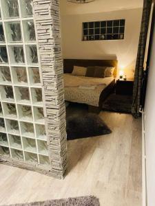 Habitación con cama y pared con bloques de cristal. en Lovely 1 bedroom flat in a 2 ground floor house, en Craiova