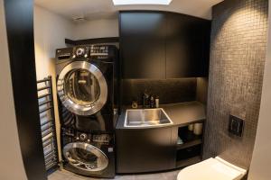 a bathroom with two washing machines and a sink at Entire Knightsbridge Mews House in London