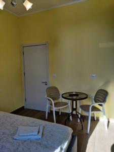 um quarto com uma cama, uma mesa e cadeiras em Auto Tana Guest House em Tirana