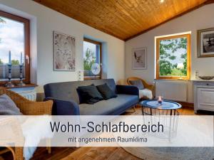 a living room with a couch and a table at Ferienhaus Töpferhaus - strandnah, haustierfreundlich, Kaminofen, Garten, Platz für 3 Erwachsene, 2 Kinder in Steinberg