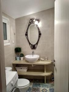 La salle de bains est pourvue d'un lavabo, de toilettes et d'un miroir. dans l'établissement Rizaki Cottage in Nafpaktos, à Naupacte