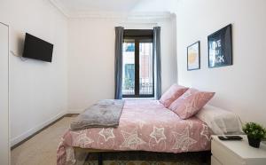 ein Schlafzimmer mit einem Bett und einem TV in der Unterkunft Antón Rooms in Madrid