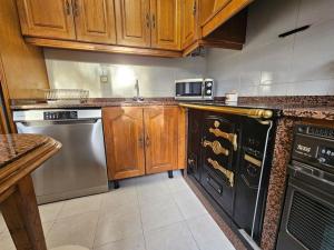 a kitchen with wooden cabinets and stainless steel appliances at 303A Casa Elisa Cudillero in Cudillero +16 photos