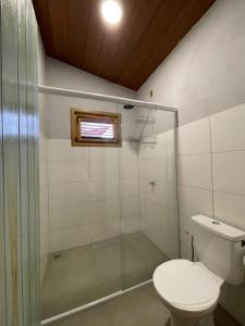 ein Badezimmer mit Toilette und Glasdusche in der Unterkunft Casa Carol - Macapá Paradise in Luis Correia