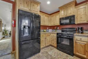 - une cuisine avec des appareils noirs et des armoires en bois dans l'établissement 2414-Knotty Pines Log Cabin cabin, à Big Bear City