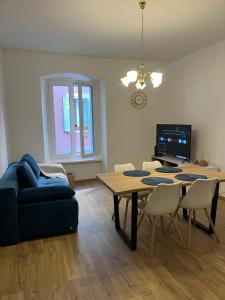 ein Wohnzimmer mit einem Tisch und einem blauen Sofa in der Unterkunft Collie’s place in Koper