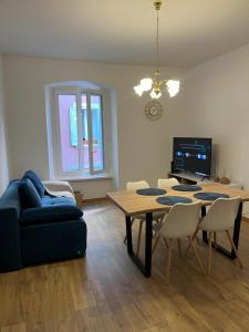 a living room with a table and a blue couch at Collie’s place in Koper