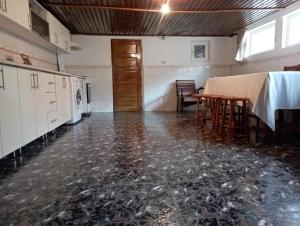 Casuta de sub munte في بوزاو: غرفة فارغة مع طاولة وكراسي في مطبخ