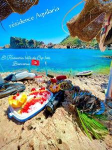 Résidence Dar Mariem في الهوارية: مجموعة من الطعام على الشاطئ مع الماء