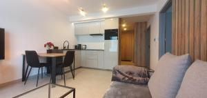 a kitchen and a living room with a table and a couch at Design Apartment in Bolszewo