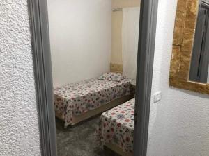 um pequeno quarto com 2 camas e um espelho em Résidence Dar Mariem em El Haouaria