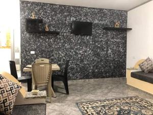Résidence Dar Mariem في الهوارية: غرفة معيشة مع أريكة وتلفزيون على الحائط
