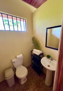 y baño con aseo y lavamanos. en Casa Ceiba, en Puerto Jiménez