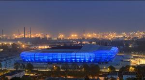 a blue soccer stadium with a city at night at Appartement Cosy et fonctionnel 4 personnes in Le Havre