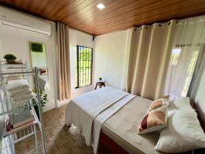 1 dormitorio con cama y ventana en Casa Ceiba, en Puerto Jiménez