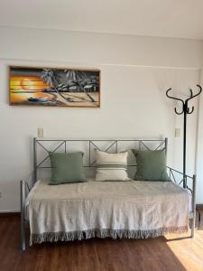2 amb,palermo,centrico,pileta,sum,nuevo,luminoso,climatizado,excelente في بوينس آيرس: سرير مع وسادتين وصورة على الحائط