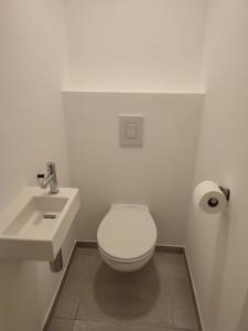 uma casa de banho branca com um WC e um lavatório em Magnifique Appartement Spacieux Liège Centre em Seraing