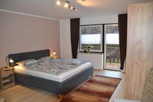 um quarto com uma cama grande e 2 janelas em Ferienwohnung Vera em Georgensgmünd