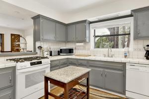 a kitchen with gray cabinets and white appliances at 2382-Belmont Pines Cottage cabin in Big Bear City