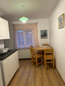a kitchen with a table and chairs in a room at Lala's Home in Ploieşti